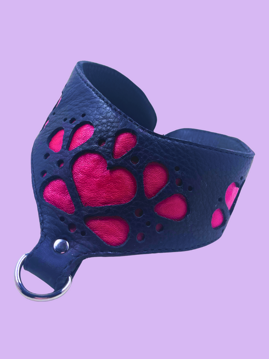 Black leather posture collar with red heart designs on a purple background